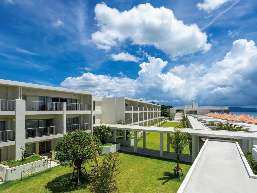 an exterior view of an apartment building with a lawn at Private condo Kourijima by Coldio Smart Resort in Nakijin