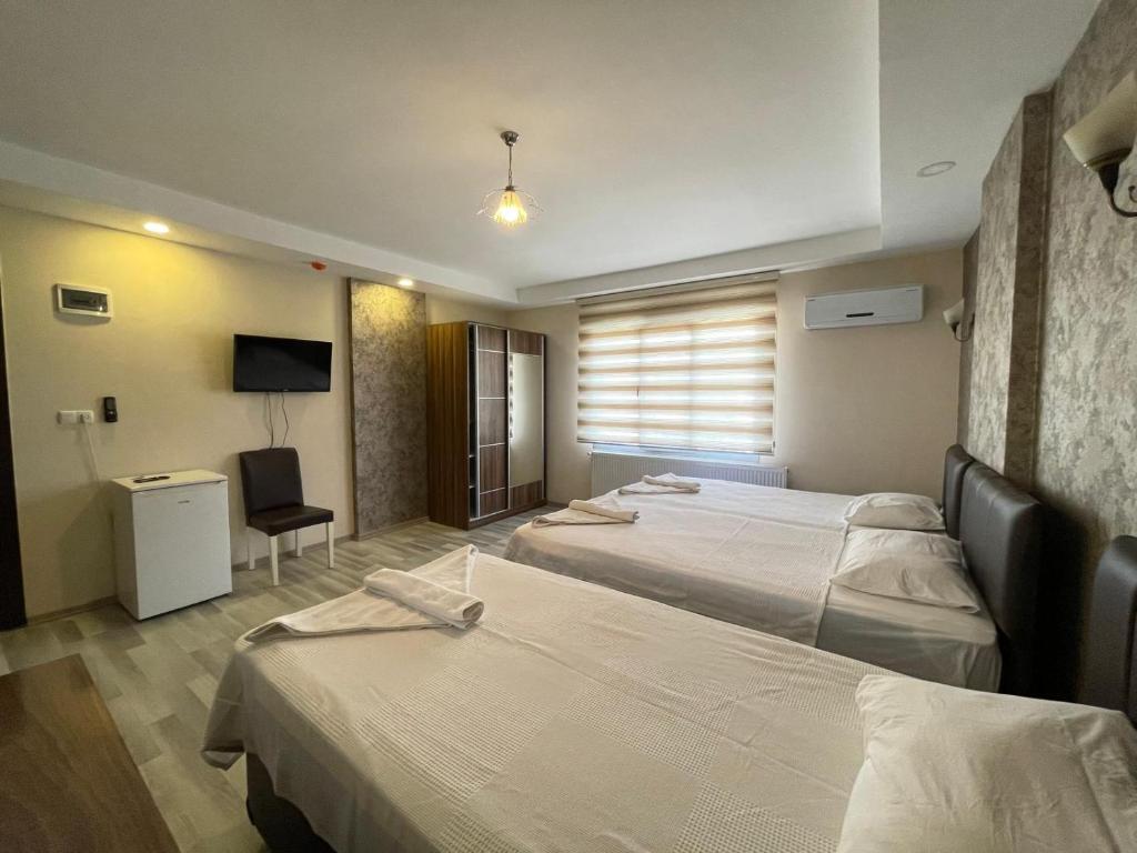 Habitación de hotel con 2 camas y TV en İkarus Hotel, en Kusadasi