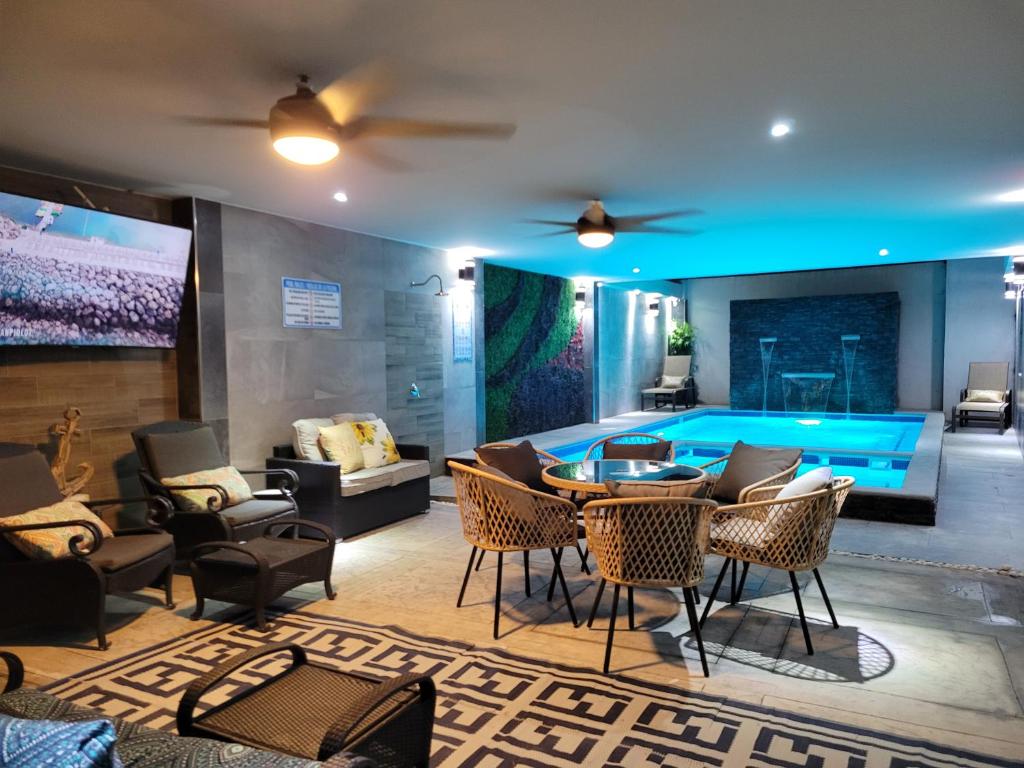 ein Wohnzimmer mit einem Pool, einem Tisch und Stühlen in der Unterkunft Sonoran desert in Puerto Peñasco