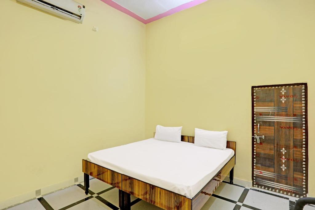 um quarto com uma cama no canto de um quarto em OYO J.M.D Restaurant &rooms em Jhājhar