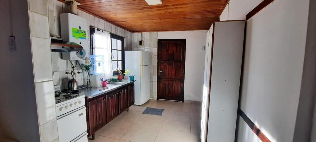a kitchen with a wooden ceiling and a wooden door at La casa del Marino in Ushuaia