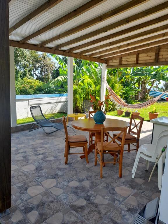 d'une terrasse avec une table, des chaises et un hamac. dans l'établissement Au petit salako, à Capesterre-Belle-Eau