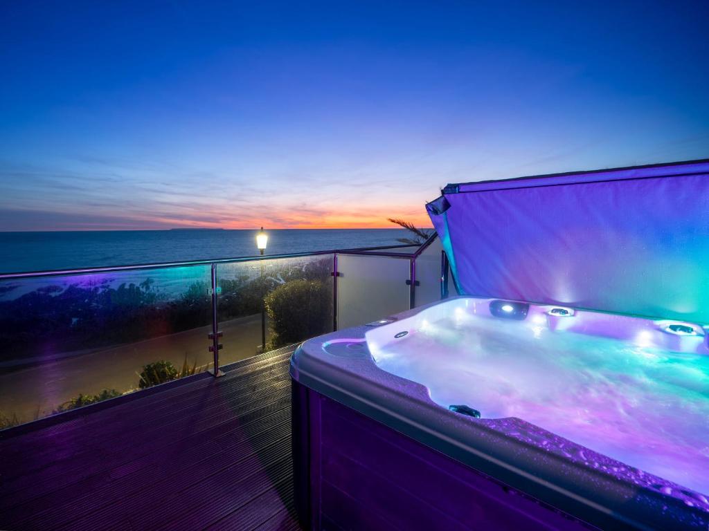 a bath tub on a balcony with a view of the ocean at 1 Little Beach in Woolacombe