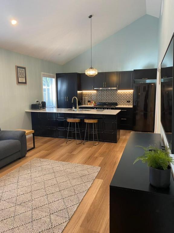 a kitchen and living room with a couch and a table at Selby Cottage in Katoomba