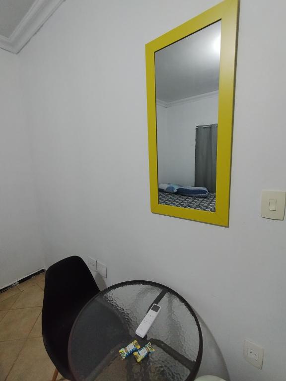 a glass table in a room with a mirror at Hotel Indi Suíte Quádruplo in Ribeirão Preto