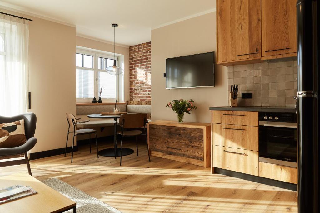 Una cocina con gabinetes de madera y un comedor. en Binnendiek Haus 1 Apartment 2, en Büsum