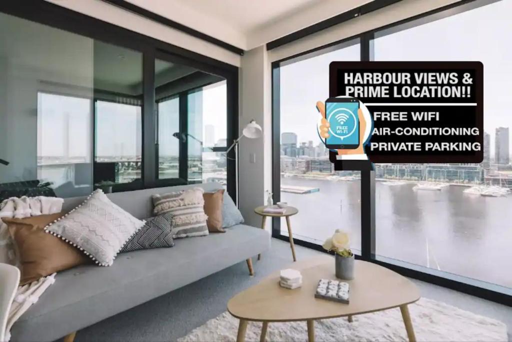 sala de estar con sofá y ventana grande en Premier Harbour View & Parking near Marvel Stadium, en Melbourne