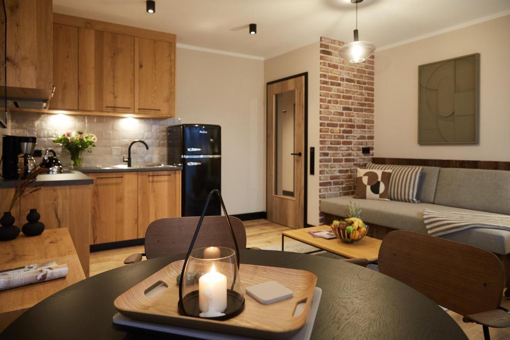 eine Küche und ein Wohnzimmer mit einem Tisch mit einer Kerze in der Unterkunft Binnendiek Haus 1 Apartment 6 in Büsum
