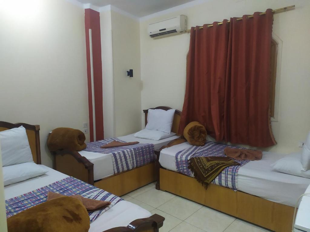 una habitación con 2 camas con animales de peluche. en Dahab hotel, en Sūhāj