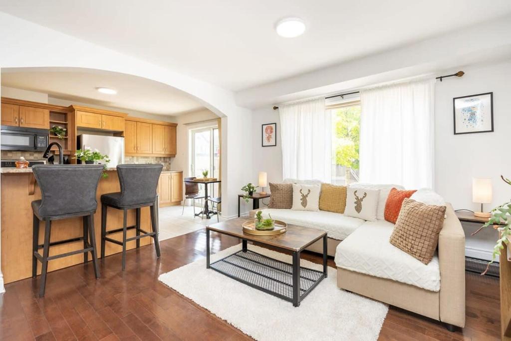 uma sala de estar com um sofá e uma mesa em Modern Cozy 4BR Home with Sunny Patio em Ottawa