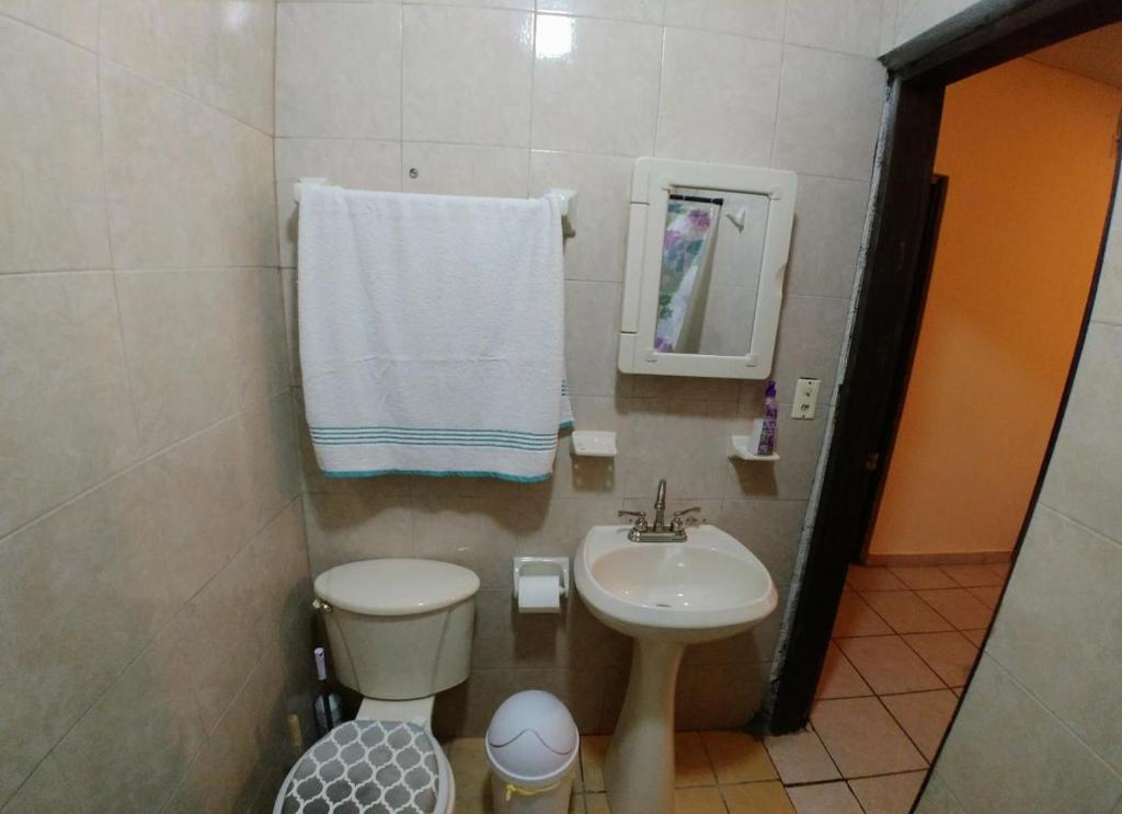 W łazience znajduje się umywalka, toaleta i lustro. w obiekcie MyM Departamentos w mieście Matamoros