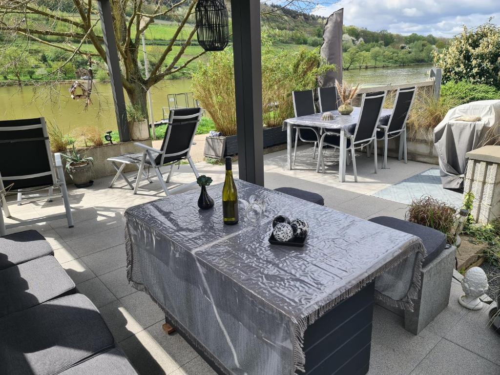 a table with a bottle of wine on a patio at Ferienhaus am Fährkopf in Zell an der Mosel