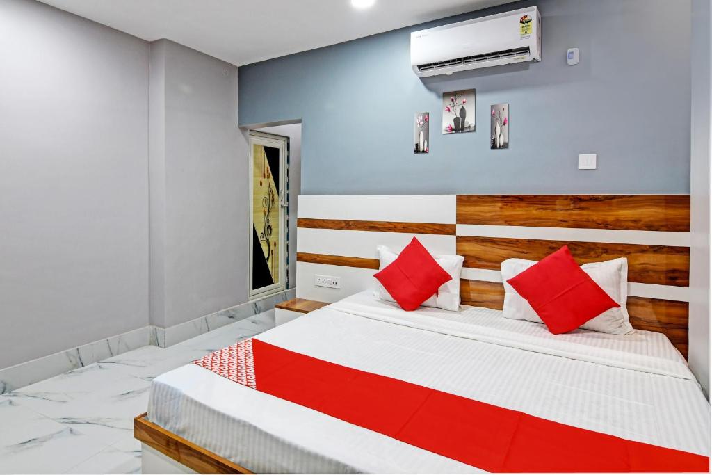 a bedroom with a large bed with red pillows at OYO Tara Maa Guest House in Kolkata