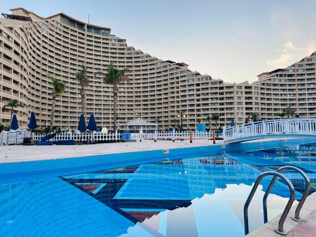 a large hotel with a swimming pool and a large building at Chalet in Porto Sokhna Beach Resort in Ain Sokhna