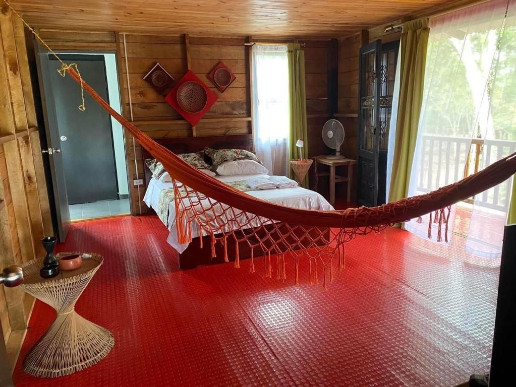 a hammock in a room with a bedroom at ACORI WUHU in Mitú