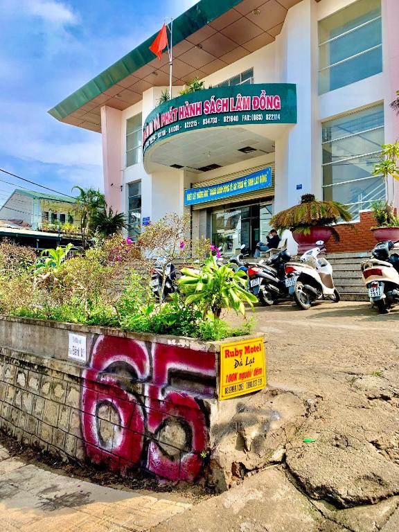 a building with graffiti on it with motorcycles parked in front at 65 RuBy Motel in Da Thanh