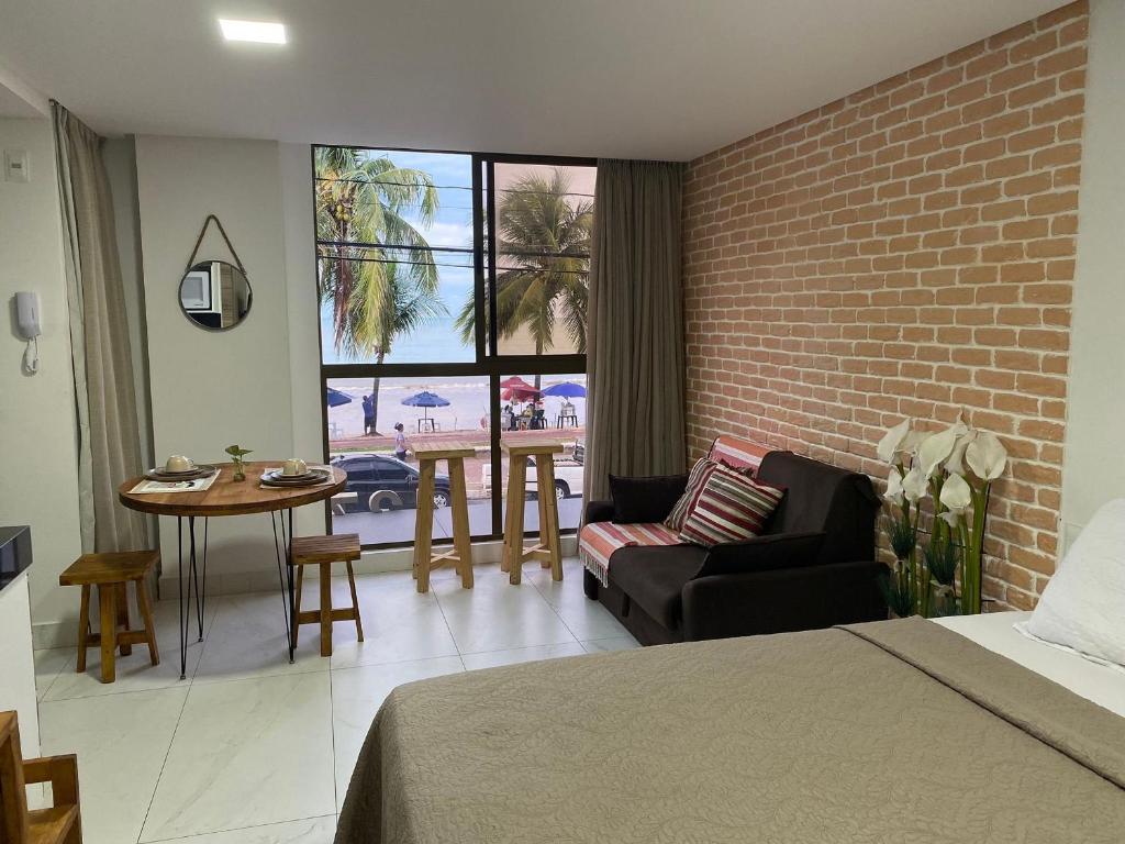a bedroom with a couch and a chair and a table at Beautiful Accommodation - #Unity Flats Cabo Branco in João Pessoa