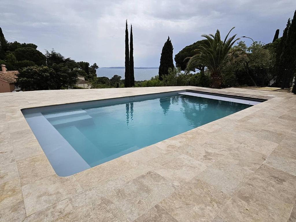 a swimming pool with blue water in a yard at Maison Les Issambres, 3 pièces, 6 personnes - FR-1-768-79 in Saint-Peïre-sur-Mer