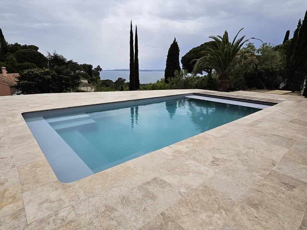 une piscine avec de l'eau bleue dans une cour dans l'établissement Rez de villa avec piscine privée chauffée et jardin, à 1 km de la mer - FR-1-768-79, à Saint-Peïre-sur-Mer