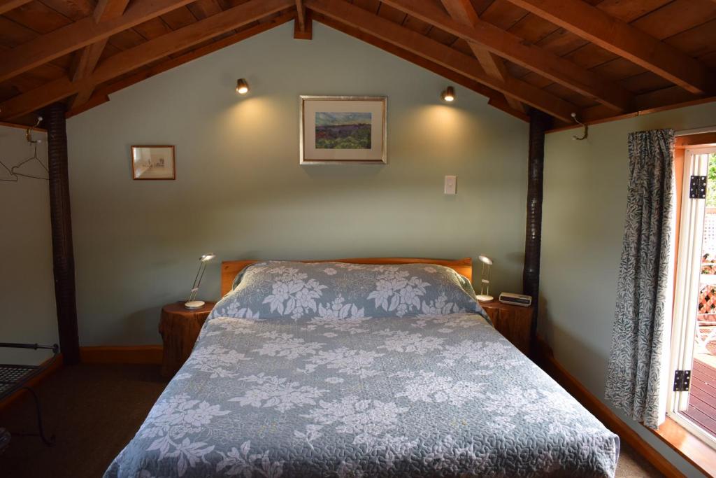 1 dormitorio con 1 cama en una habitación con ventana en Dylans Country Cottages en Kaikoura