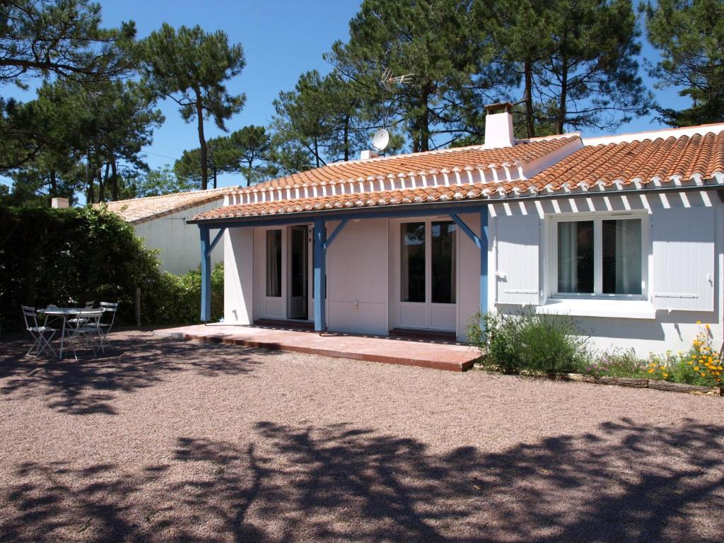 une maison blanche avec une table devant elle dans l'établissement Maison 3 Chambres avec Jardin et Wi-Fi à 10 min de la Plage, Quartier Calme, Animaux Acceptés - FR-1-323-370, à Saint-Jean-de-Monts