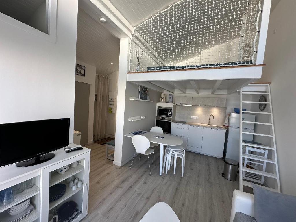 une petite pièce avec une cuisine et un lit mezzanine dans l'établissement Appartement lumineux et spacieux à deux pas de la plage de Seignosse - FR-1-239-1042, à Seignosse