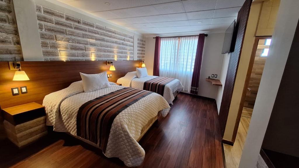 Hotel de Sal Atipax في أويوني: غرفة فندقية بسريرين ونافذة