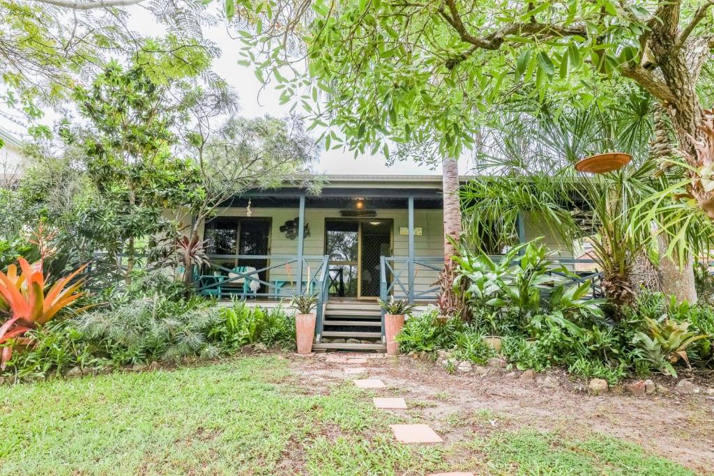 a house with a front porch with trees at The Little House - Pet-friendly beach cottage in Agnes Water