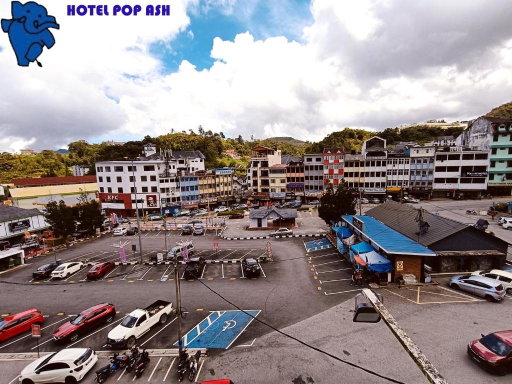 una ciudad con coches estacionados en un estacionamiento en HOTEL POP ASH, en Brinchang