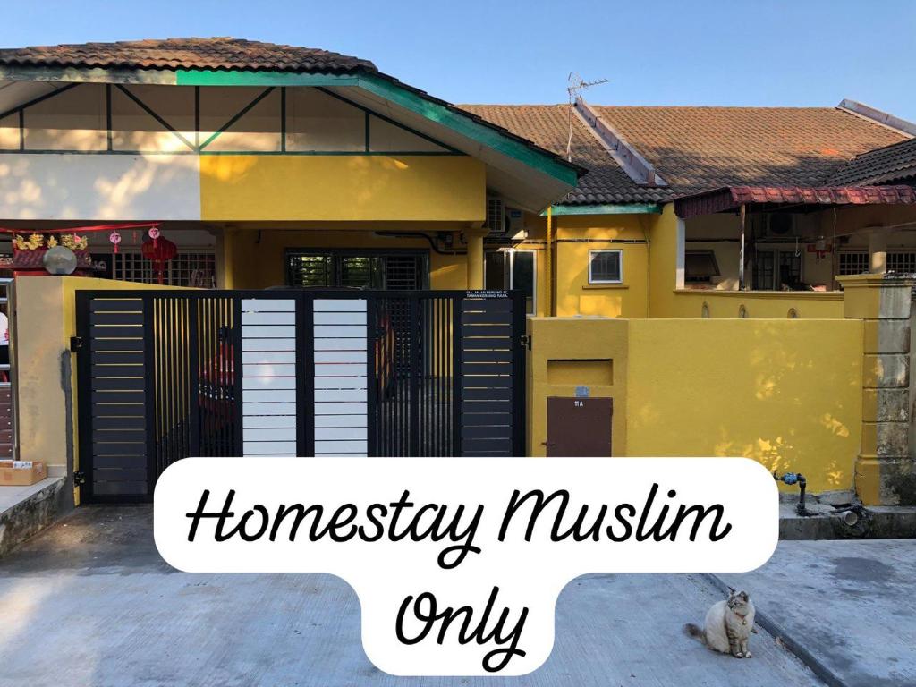 a cat sitting in front of a house at irdahusna homestay 