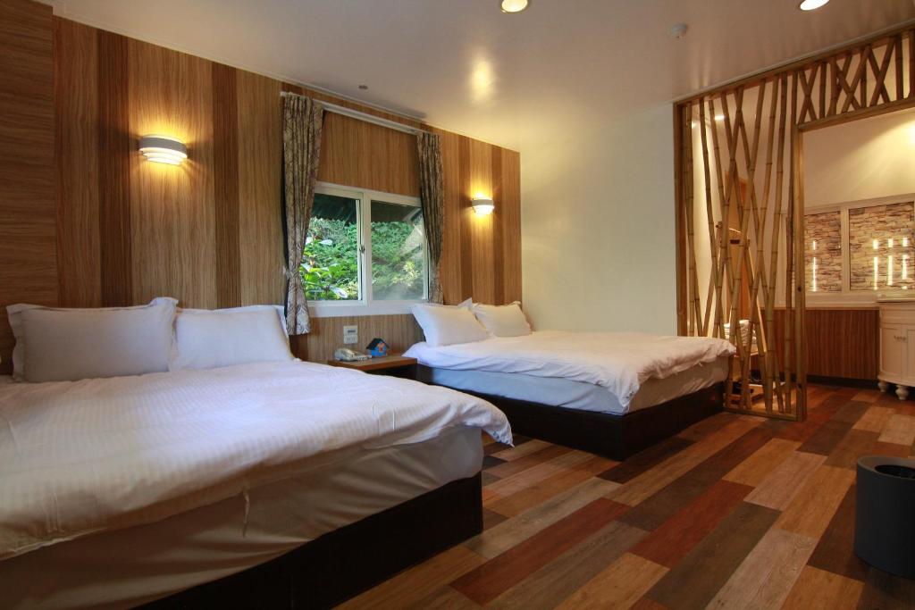 a hotel room with two beds and a window at Tingtau Villa in Lugu Lake