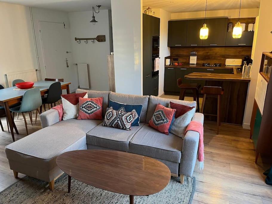 un salon avec un canapé et une table dans l'établissement Maison avec grand jardin proche de Pegasus Bridge, à Ranville