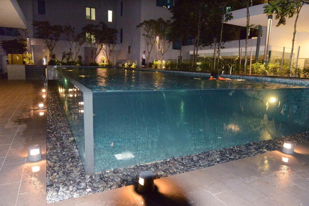a swimming pool at night with candles around it at Summer Suites Studios in Kuala Lumpur