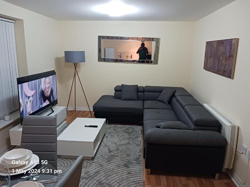 POTTERS LOGDE LIVERPOOL by Edl Ventures Ltd في ليفربول: غرفة معيشة مع أريكة وتلفزيون