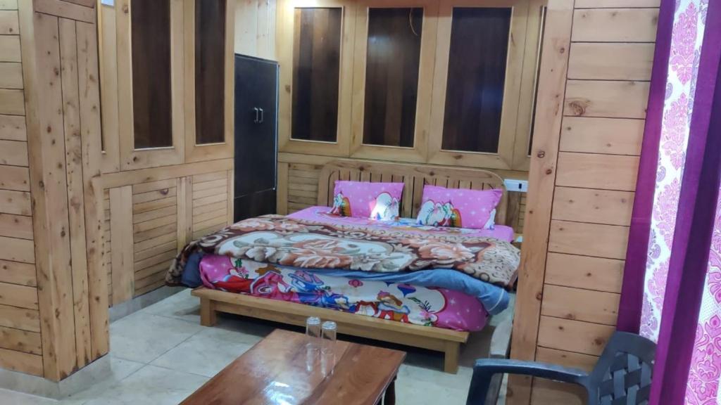 una camera con letto e parete in legno di Goroomgo Payal Lake View Mall Road Nainital a Nainital