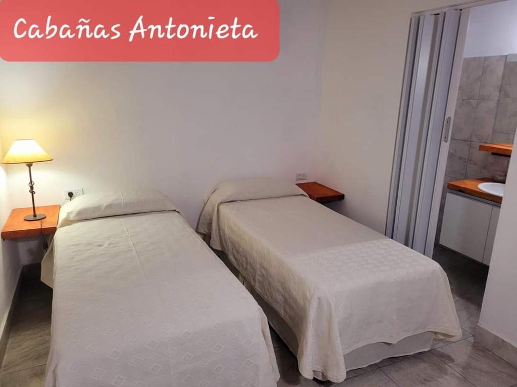 a bedroom with two beds and a sign that reads cecilia earthquake earthquake at Cabañas Antonieta in Salta