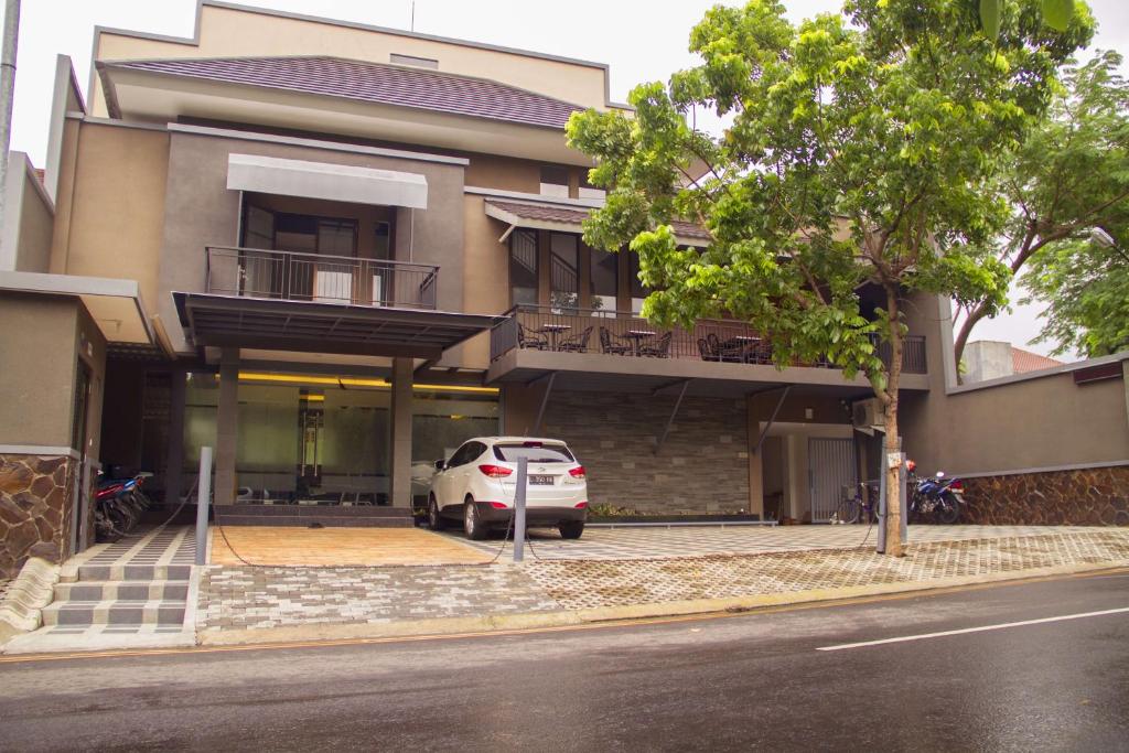 un coche blanco estacionado frente a un edificio en Kana Citra Guesthouse, en Surabaya