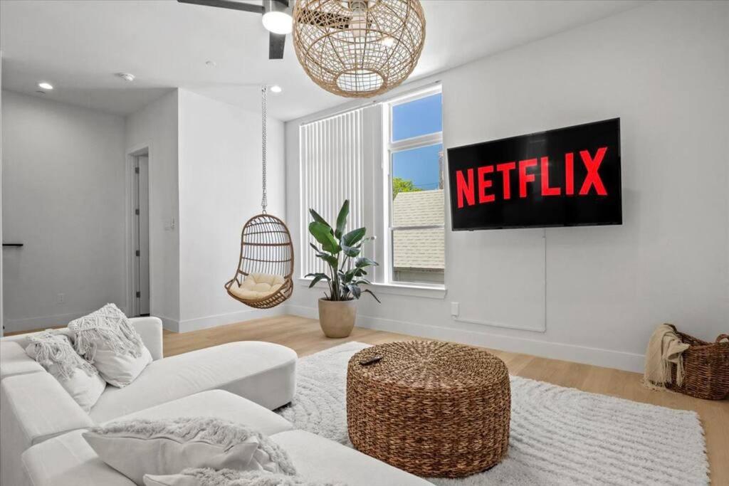 a white living room with a netflix sign on the wall at Cozy 3-bedroom townhouse with a private loft in Dallas