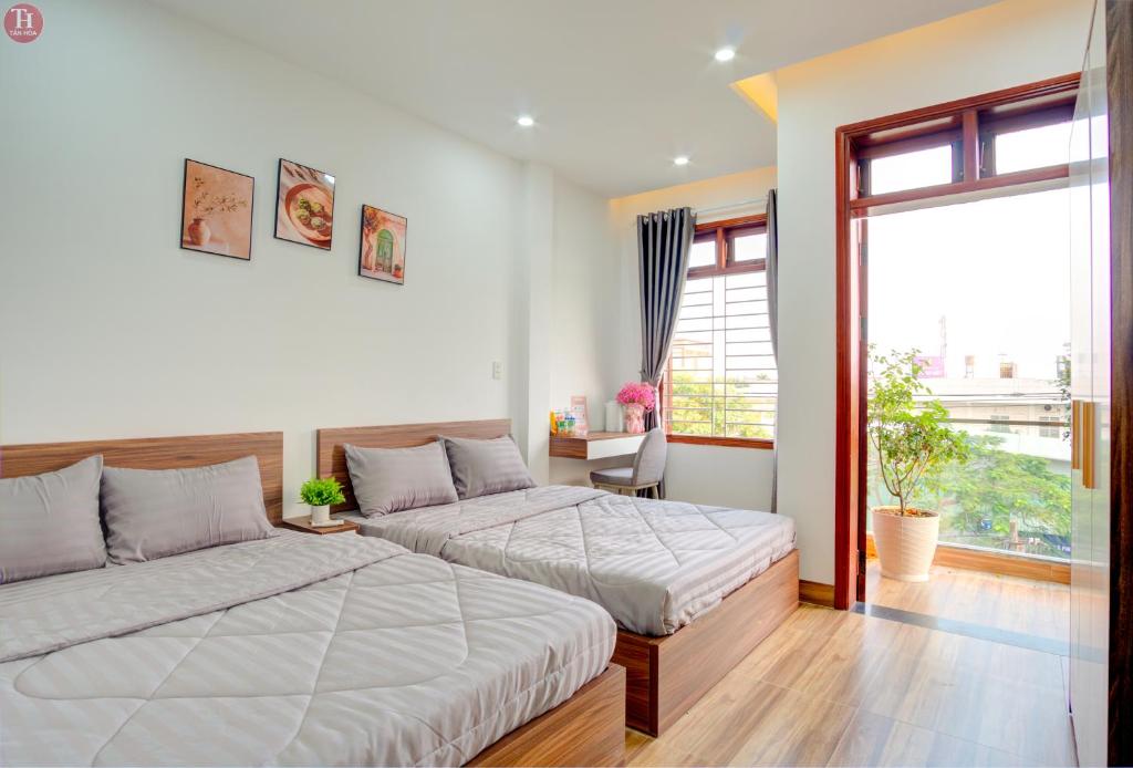 - une chambre avec 2 lits et une fenêtre dans l'établissement Tân Hoà Homestay, à Đà Nẵng