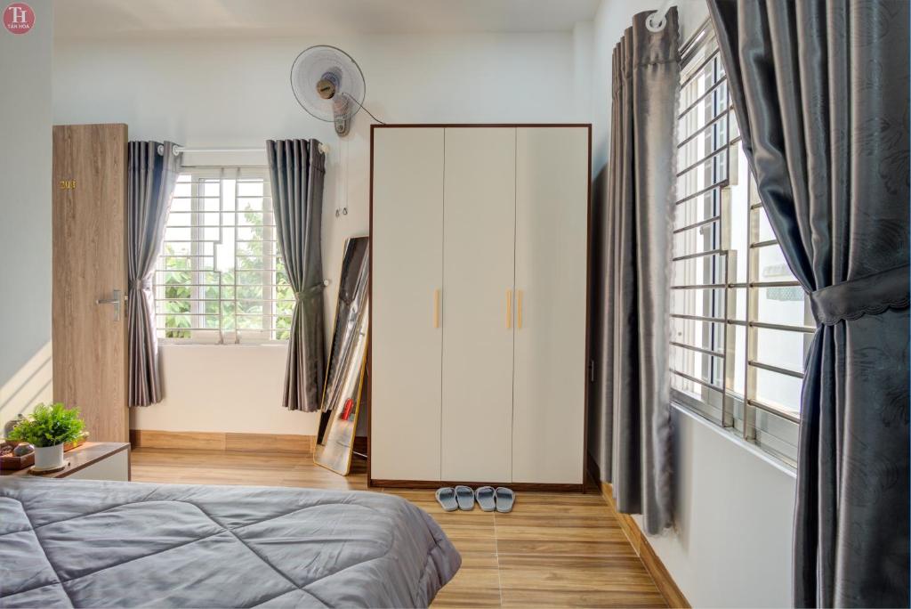 Schlafzimmer mit einem weißen Schrank und einem Spiegel in der Unterkunft Tân Hoà Homestay Da Nang in Đà Nẵng