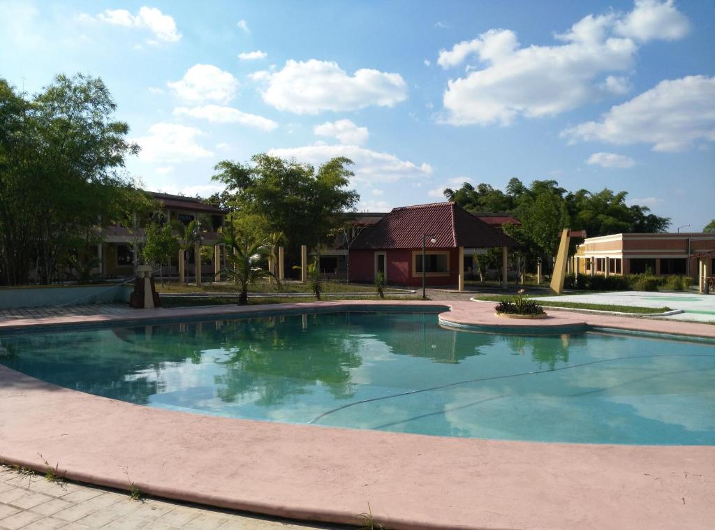 ein großer Pool in einem Hof mit einem Haus in der Unterkunft Hotel Debliz Xpujil in Chicanna