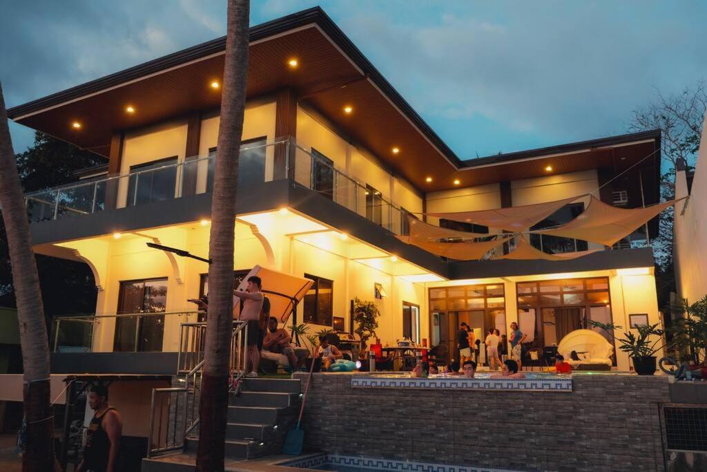 una casa con gente sentada fuera de ella en Clarin's Beach, en Pagbilao