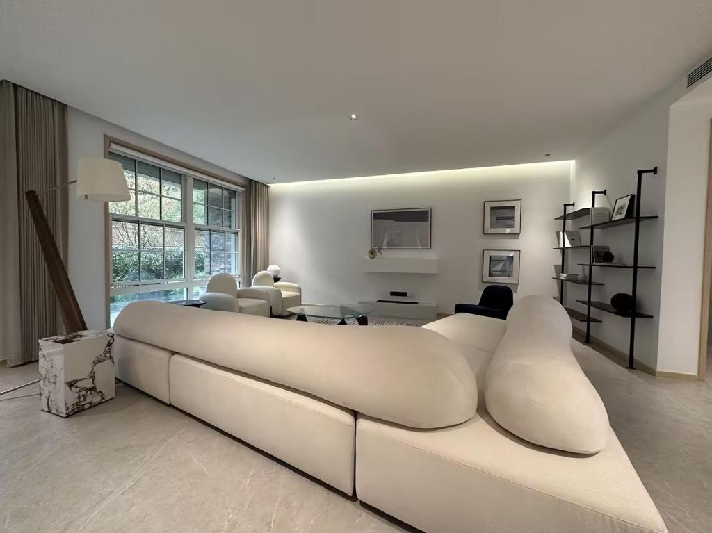 Stanford Garden في شانغهاي: غرفة معيشة بيضاء مع أريكة بيضاء كبيرة