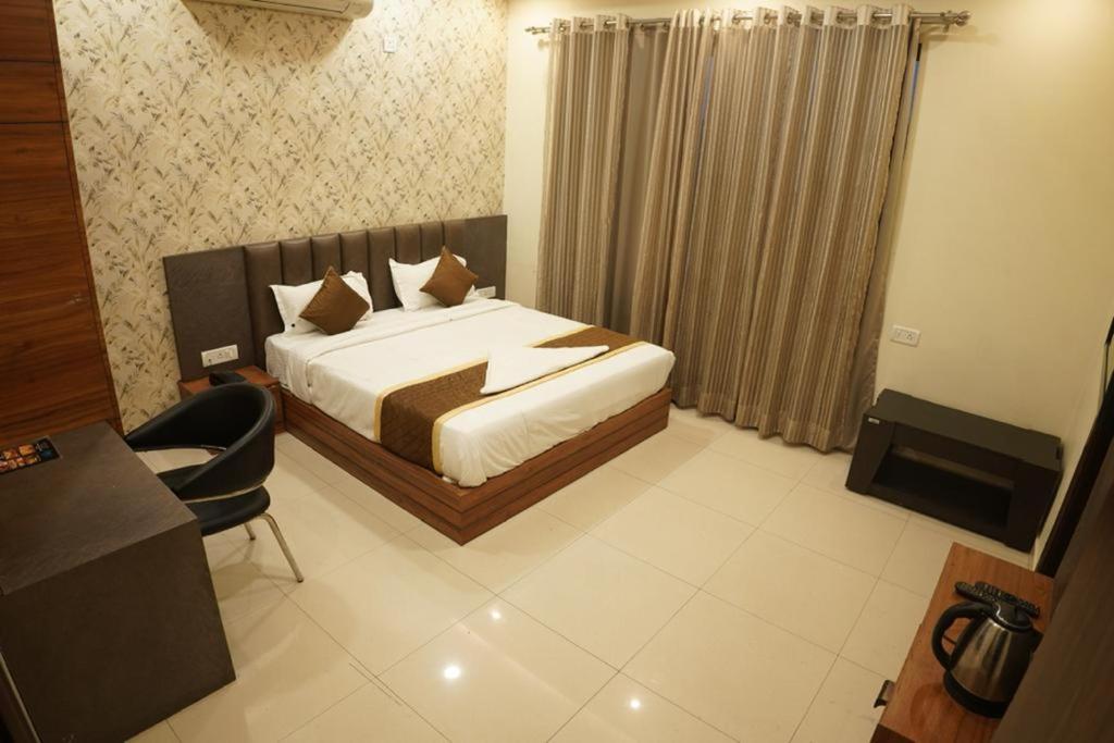 a bedroom with a bed and a desk and a chair at Hotel ashiyana stay in Lucknow