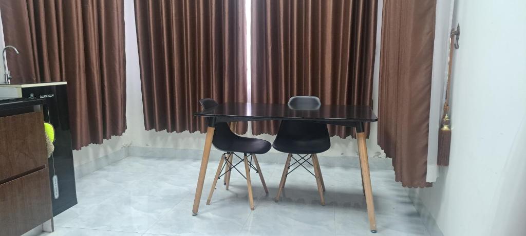 ein schwarzer Tisch und zwei Stühle in einem Zimmer in der Unterkunft Good place for your vacations 