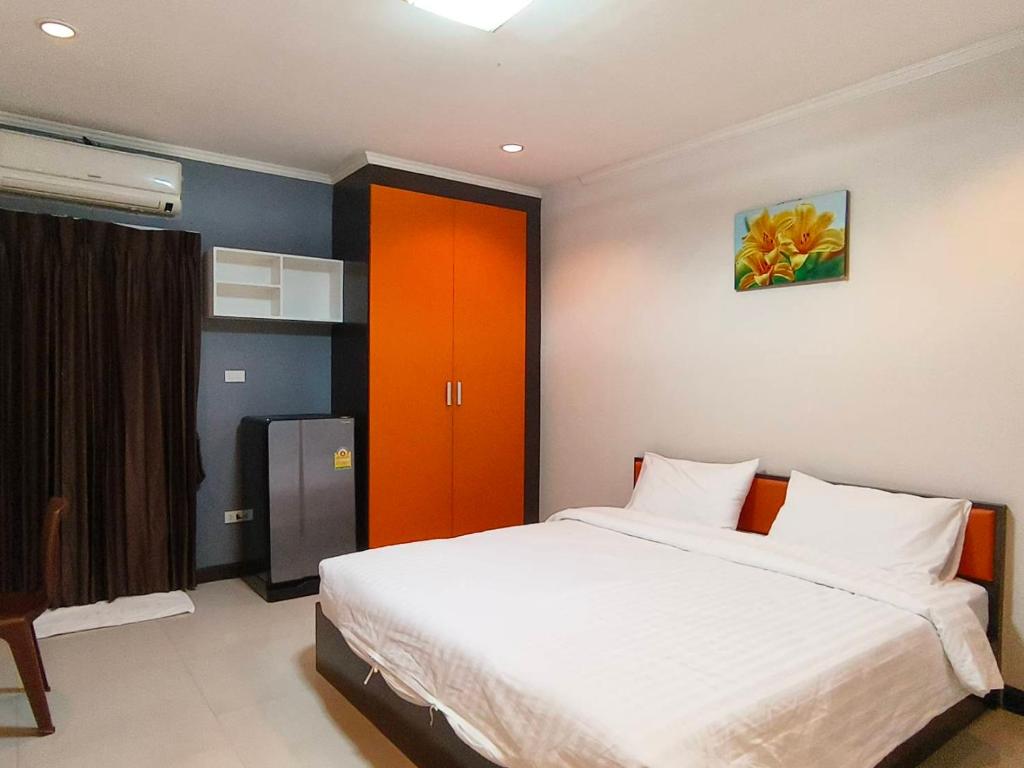 - une chambre avec un lit et une porte rouge dans l'établissement Jt Place Buriram, à Buriram