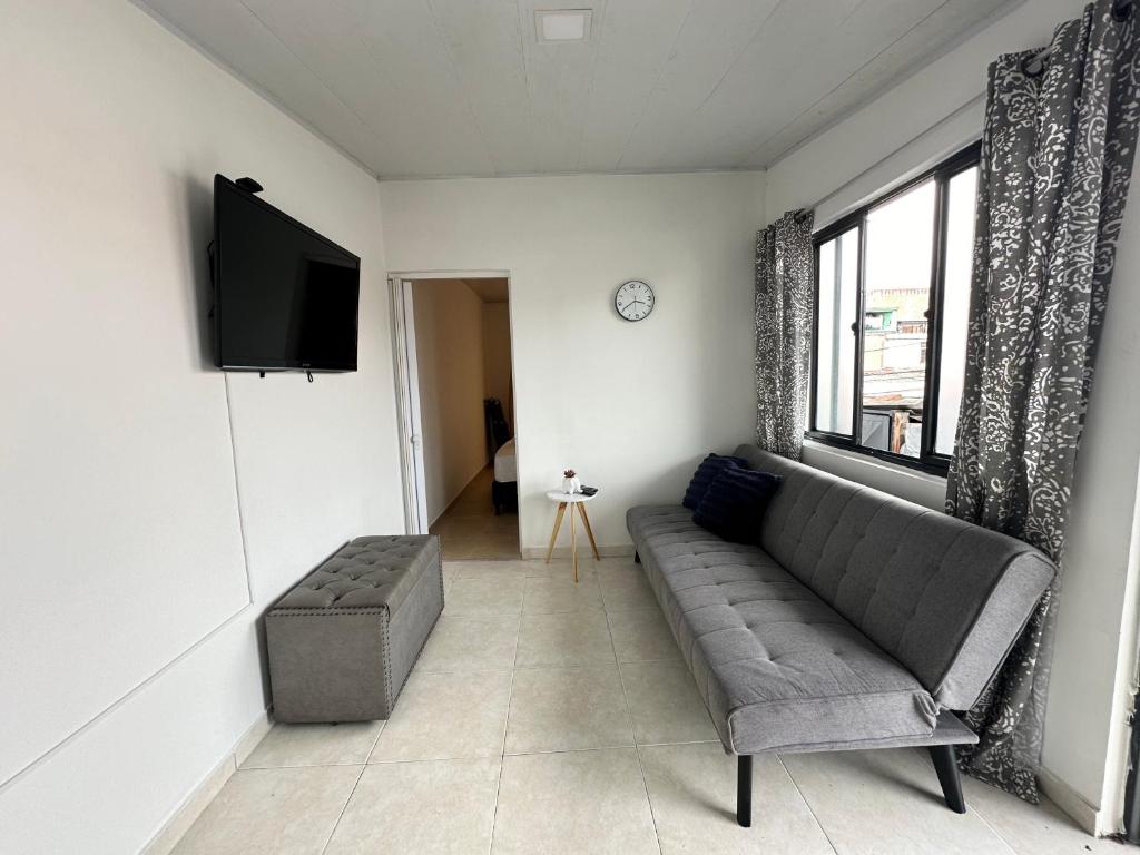 ein Wohnzimmer mit einem Sofa und einem Flachbild-TV in der Unterkunft Cómodo Apartamento Cerca Al Aeropuerto in Pereira
