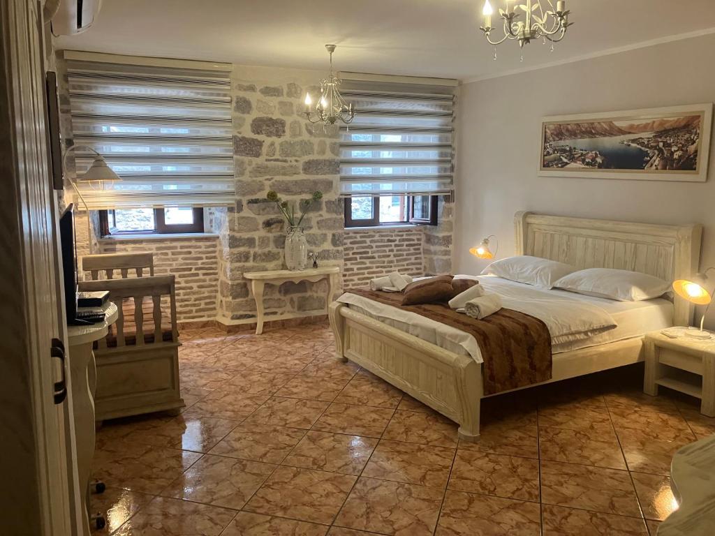 a bedroom with a bed and two windows at Apartments Parteli in Kotor