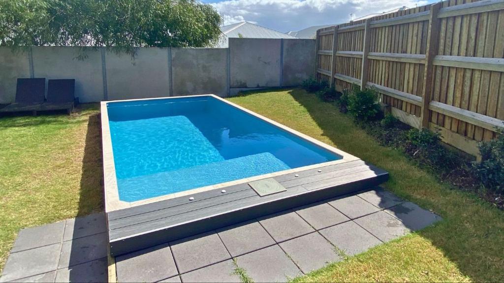 a swimming pool in a yard next to a fence at Surf and Dunes in Yamba