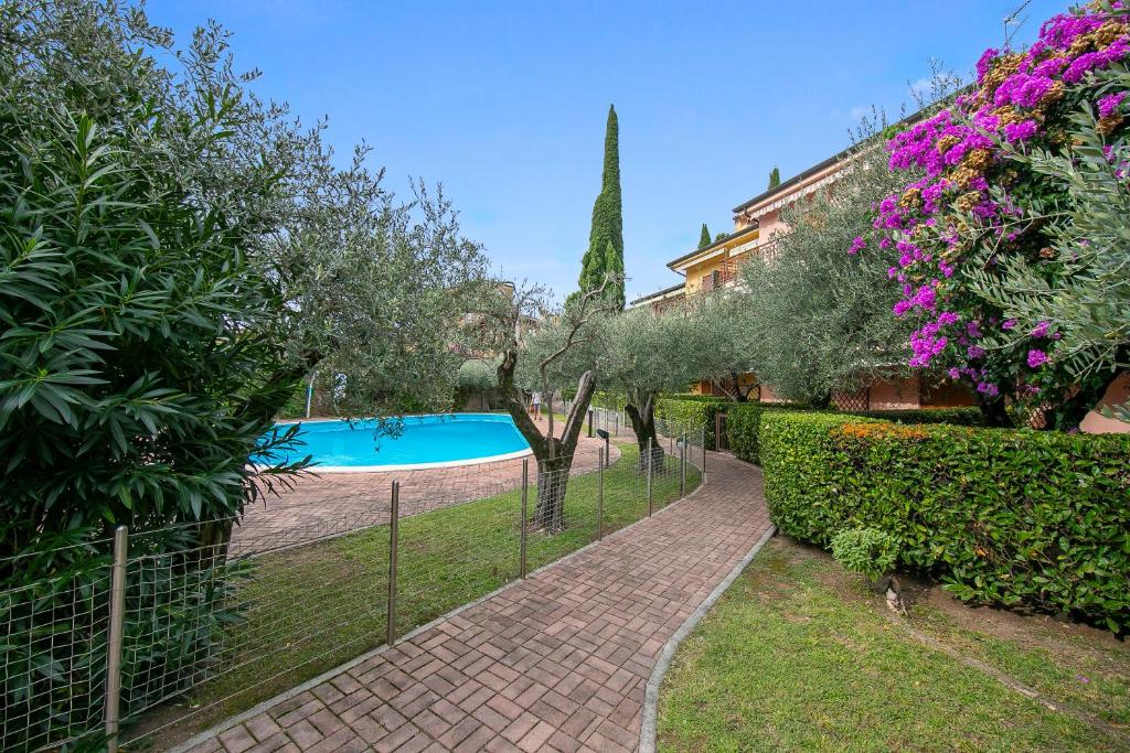 une clôture autour d'une piscine dans une cour dans l'établissement Verde Giada with pool - Happy Rentals, à Toscolano Maderno